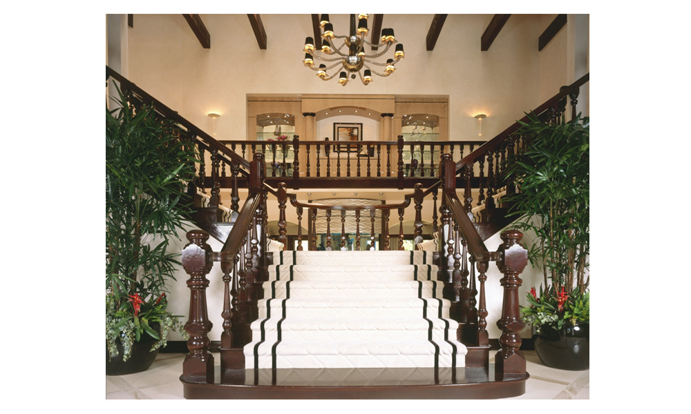 dramatic double staircase entry, grand entry, split entry staircase, formal staircase, custom white staircase runner, exposed beams, staircase chandelier, dark wood railing